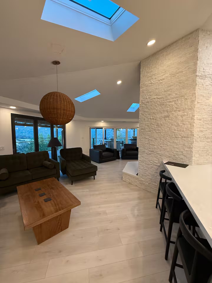 Cliff House great room with stone fireplace and skylights