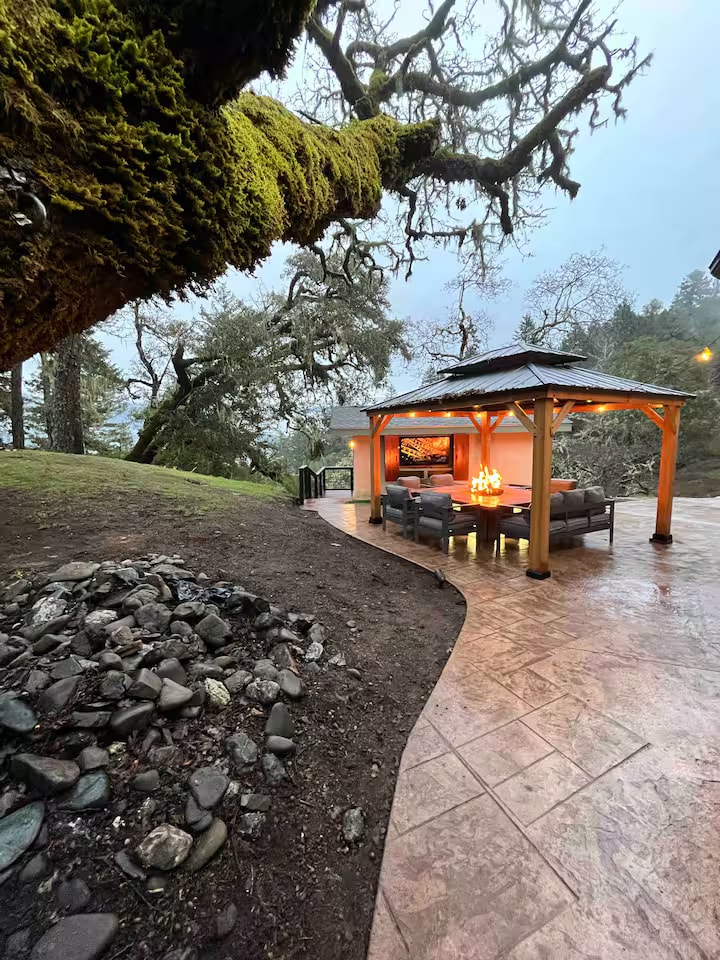 Mossy woodland patio with covered fire-pit seating