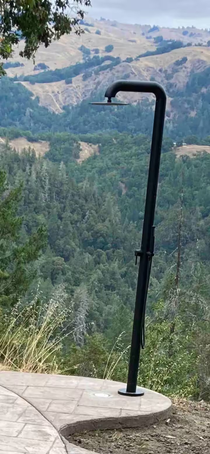 Outdoor shower overlooking the forested mountain valley